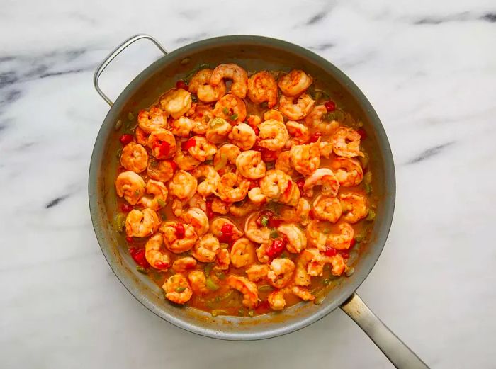 Shrimp are added to the sauce to finish cooking.