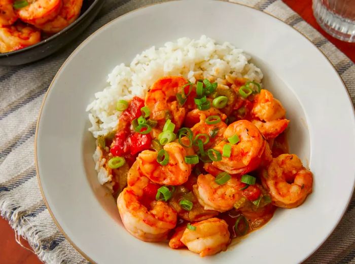 An overhead view of a bowl of étouffée served with white rice.