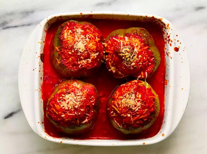 A baking dish containing four delicious homestyle stuffed peppers.