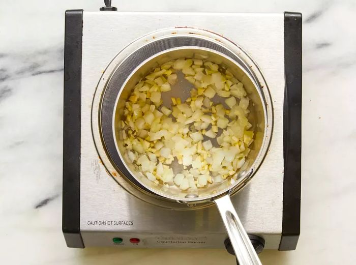 Onions cooking in a saucepan on a stovetop