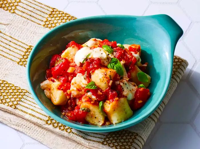 Ricotta Gnocchi topped with fresh basil and cheese in a bowl