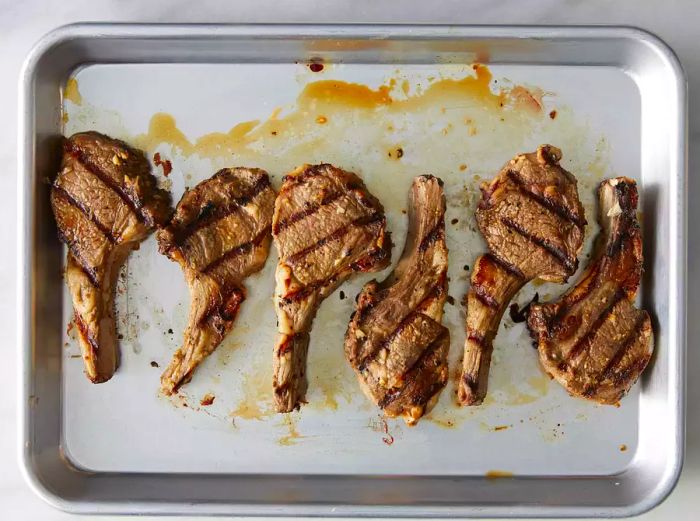 Grilled lamb chops resting on a tray