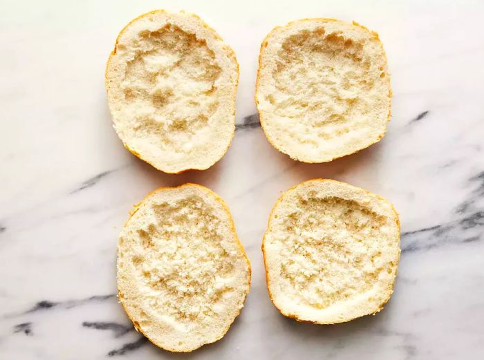 An overhead shot of four slices of bread with hollowed-out centers.