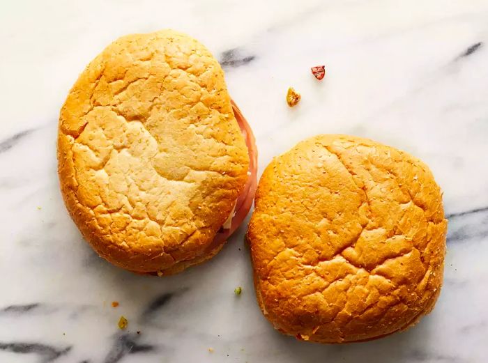 A bird's-eye view of two sandwiches resting on a counter.