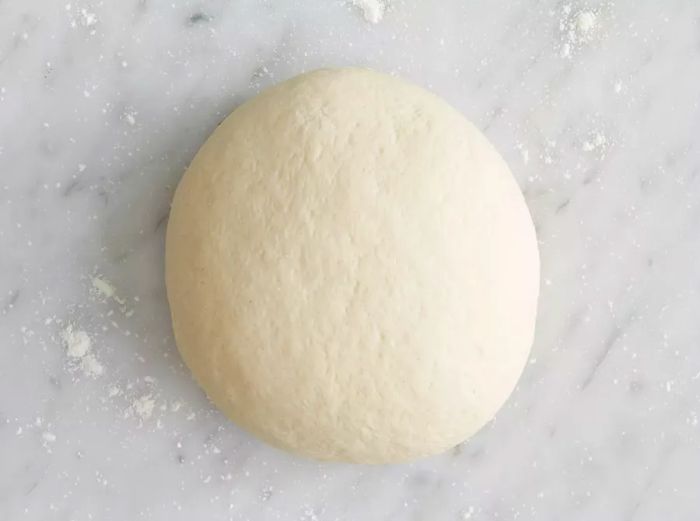 Overhead view of a ball of dough for pot stickers, shaped and ready to use.