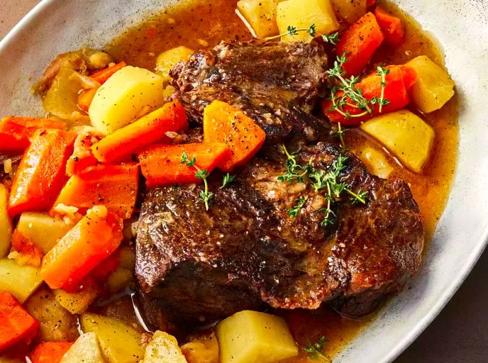 A pressure cooker pot roast served on a platter with potatoes and carrots