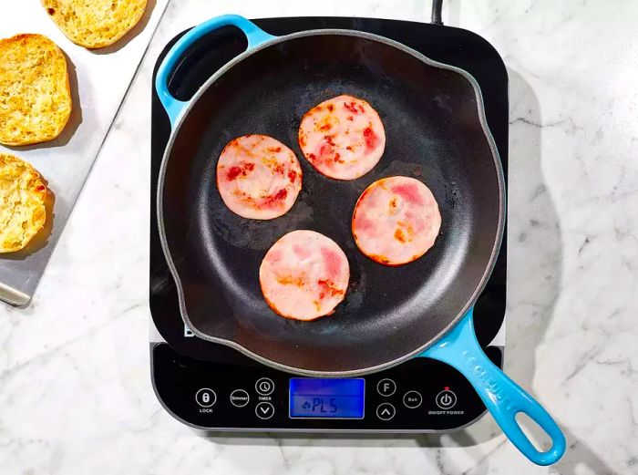 Sear the bacon in a skillet until browned and crispy.