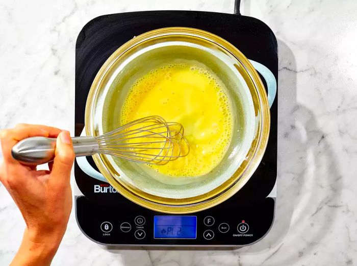 Whisk the ingredients together to create the creamy hollandaise sauce.