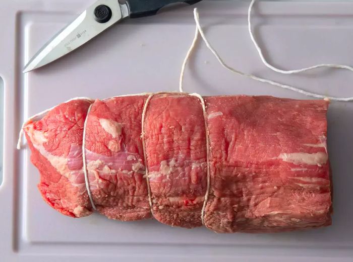 Tie cotton twine around the roast every 3 inches to secure it for even cooking.