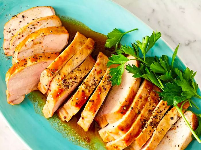 An overhead shot of sliced pork tenderloin resting on a plate.