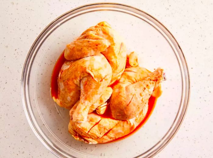 A top-down view of chicken coated with barbecue sauce in a bowl