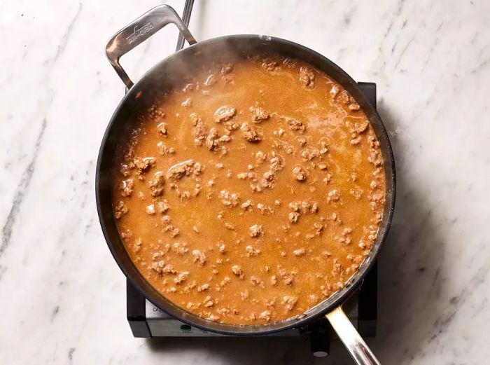 Broth mixed into the ground beef and flour.