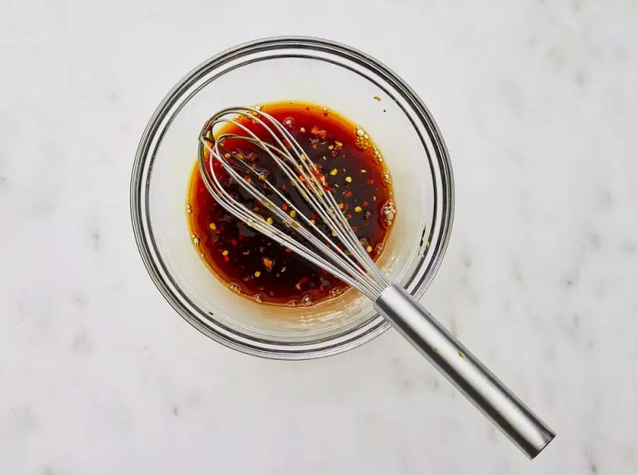 Aerial view of a mixing bowl containing the sauce for honey-glazed chicken