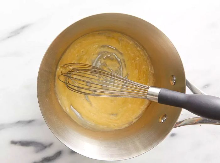 An overhead view of a pan with flour and butter being cooked together for the macaroni and cheese sauce.