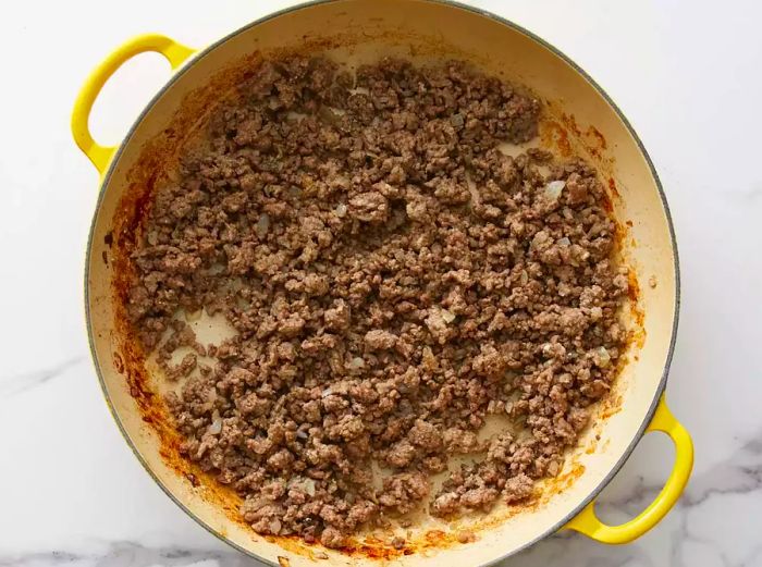 Ground beef browning and breaking apart in a skillet