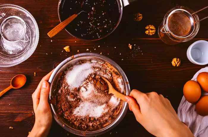 Close-up of hands mixing cocoa powder with precision in the kitchen