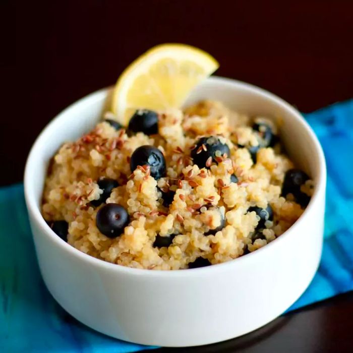 A bowl of Blueberry Lemon Breakfast Quinoa topped with a fresh lemon slice.