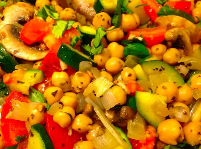 Close-up of Garbanzo Bean Stir-Fry with zucchini, onions, tomatoes, and fresh herbs