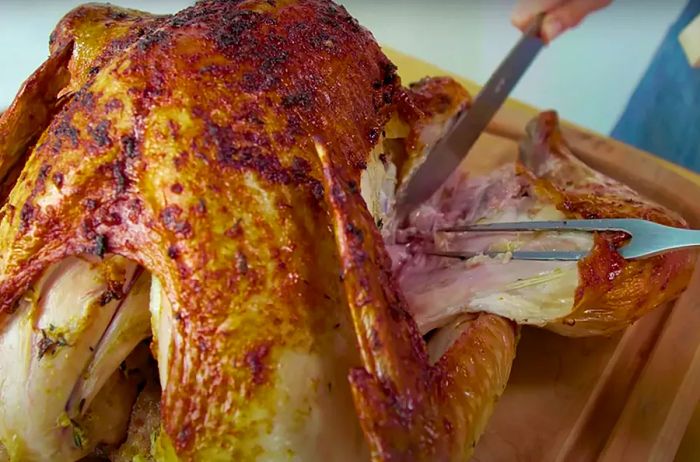 Using a carving knife and fork, carefully separate the turkey leg from the body.