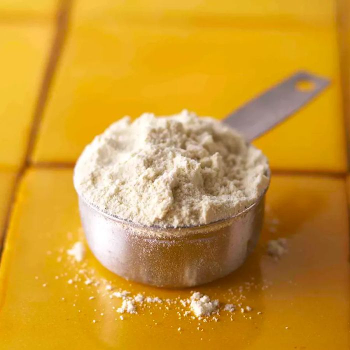 A measuring cup filled with masa harina on the kitchen counter.