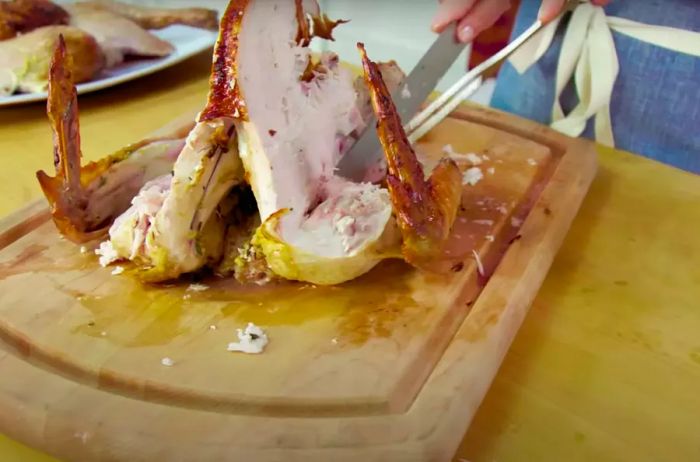 Using a carving knife and fork, gently remove the wing from the turkey.