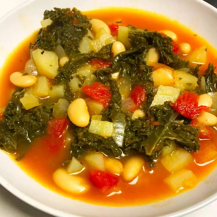 A close-up view of a warm bowl of Vegetarian Kale Soup, ready to be enjoyed