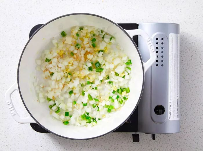 Sauté onions, garlic, ginger, and green onions in oil in a saucepan.