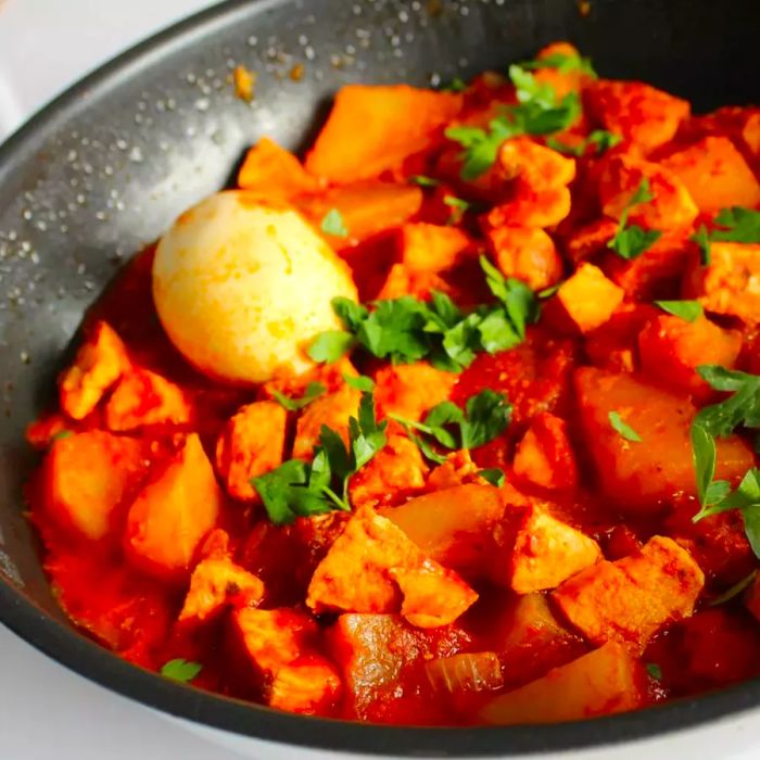 A vibrant chicken stew served with whole hard-boiled eggs