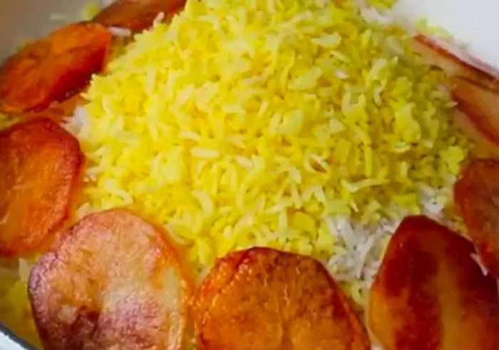 Saffron-infused rice surrounded by golden, crispy rounds of fried potato.