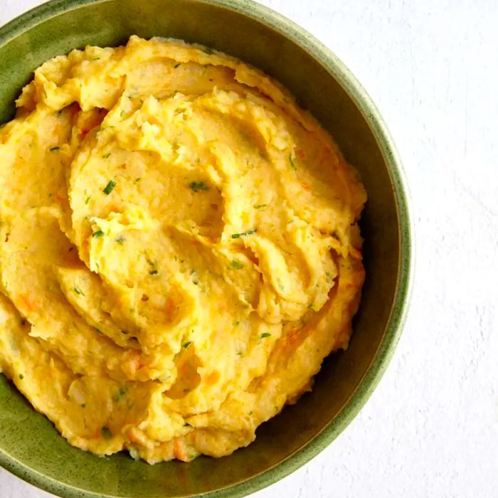 A top-down view of a bowl filled with smooth parsnip and carrot puree