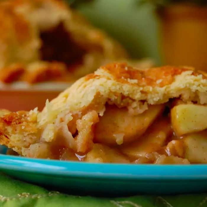 A slice of Grandma Ople's Apple Pie on a turquoise plate