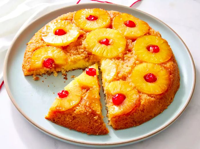 Grandma’s classic skillet pineapple upside-down cake, served with a slice removed.