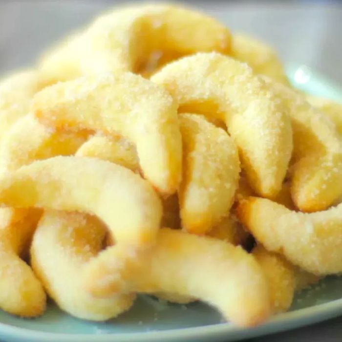 A top-down view of a dish filled with buttery crescent-shaped biscuits