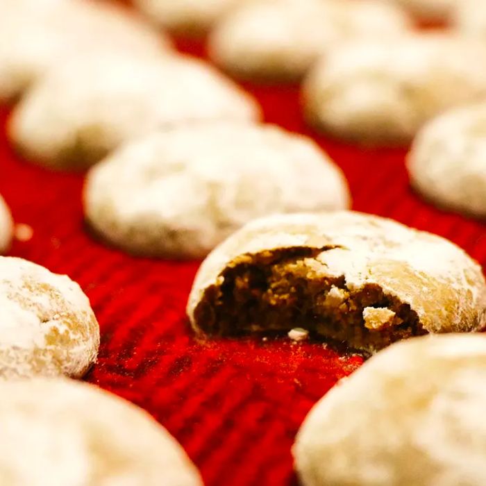 A low-angle shot of a pile of Pfeffernusse cookies, with one broken in half