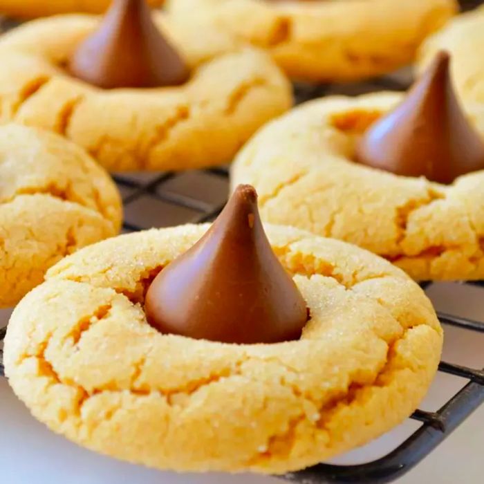 Homemade Peanut Blossoms II peanut butter cookies, each topped with a milk chocolate kiss and arranged neatly on a cooling rack