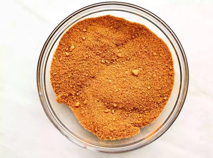 A mixture of brown sugar and cinnamon stirred together in a glass bowl.