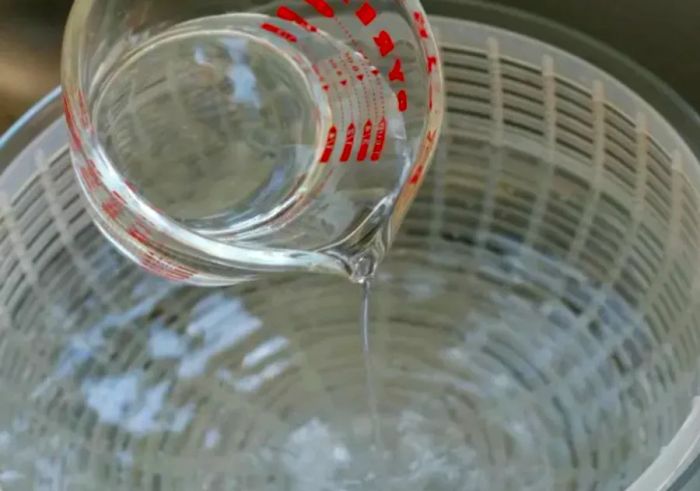 Preparing a vinegar-water soak for fresh berries.