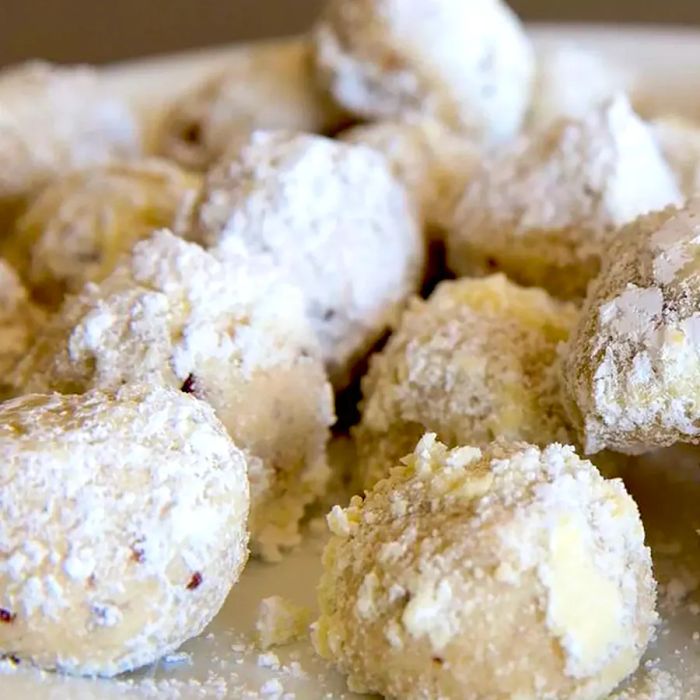 A close-up of homemade Snowballs II, coated in a dusting of confectioners' sugar