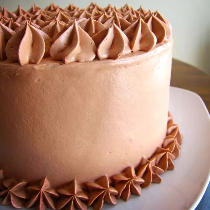 A cake topped with a delicate cocoa frosting