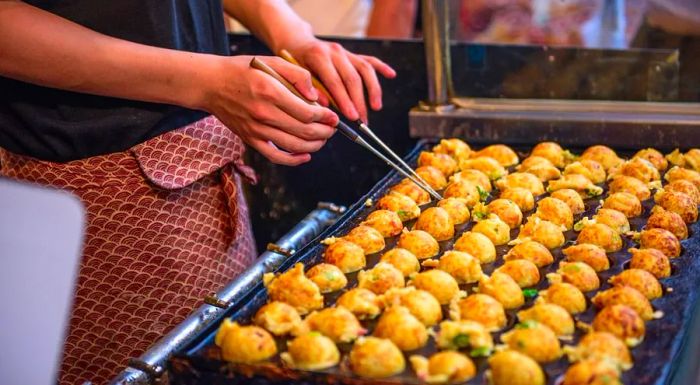 Takoyaki being freshly made at a street stall in Osaka, Japan.