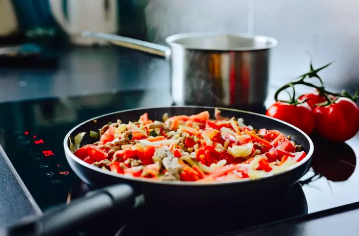 Frying minced pork and vegetables in olive oil.