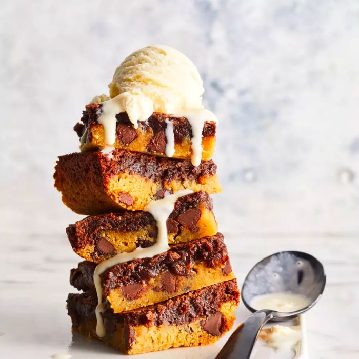 A stack of chewy brownie cookies topped with a scoop of ice cream