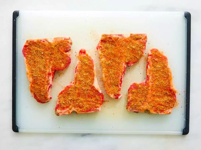 Rock's T-Bone Steaks seasoned and resting on a cutting board