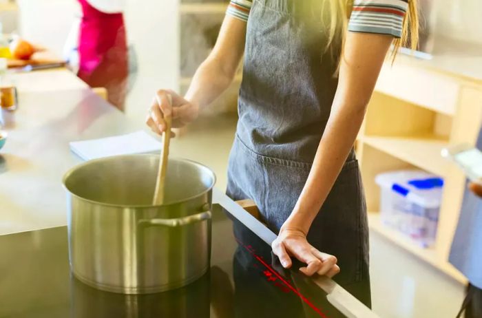 A woman stirring a pot in the kitchen