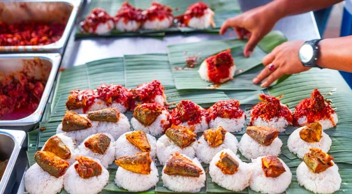 Nasi lemak consists of a rich variety of ingredients placed on a bed of fragrant coconut rice.