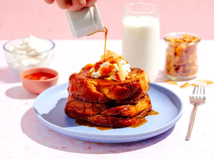 A delicious plate of French toast with syrup being generously drizzled over it.