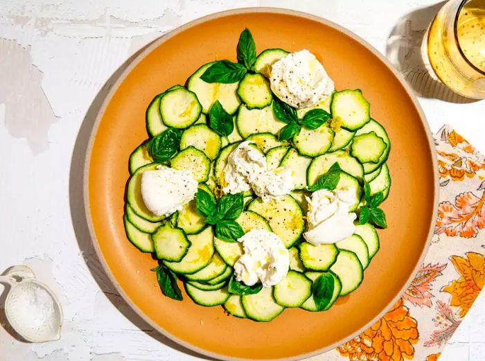 An overhead view of a plate of zucchini crudo topped with burrata