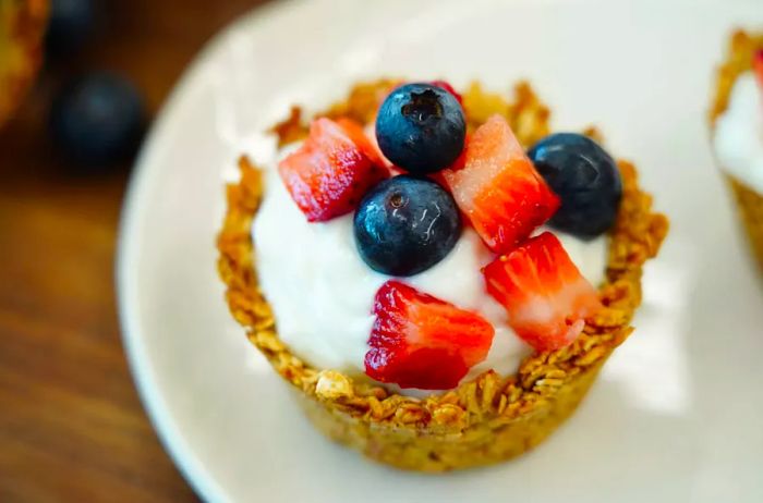 A breakfast granola cup filled with yogurt and mixed berries.