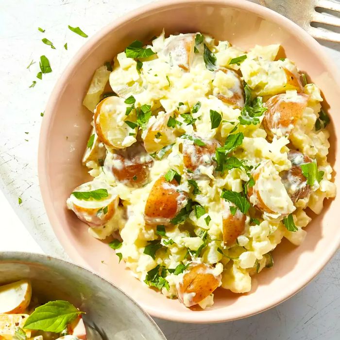 A rich, creamy potato salad with a twist of cauliflower rice added for texture.