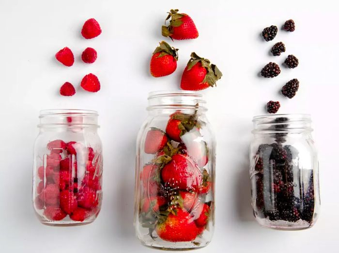 Raspberries, strawberries, and blackberries, all neatly arranged in a mason jar, photographed after two weeks of refrigeration.